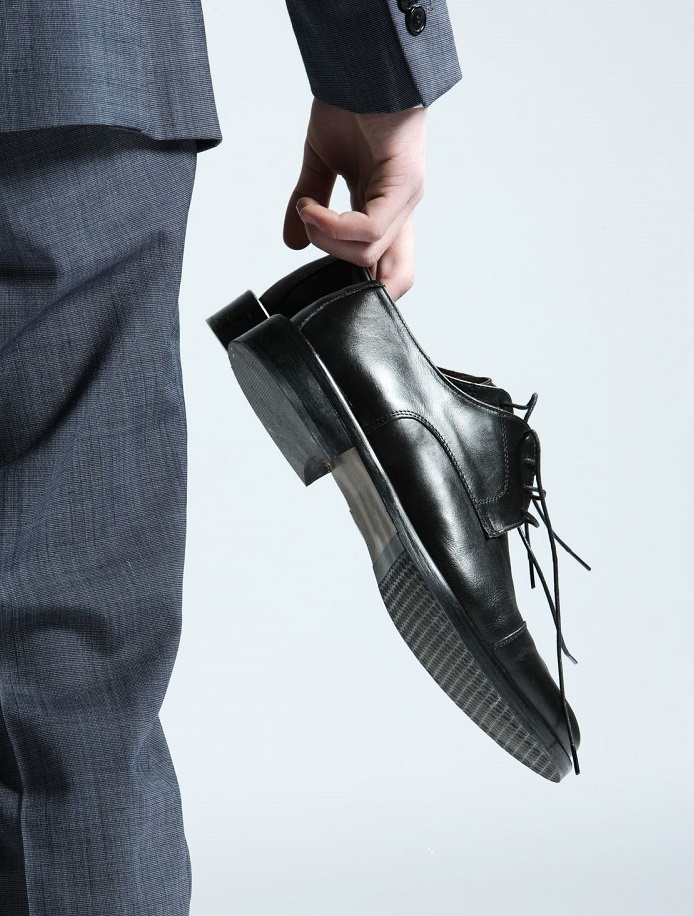 12625405 - businessman holding the shoes in hand, close up